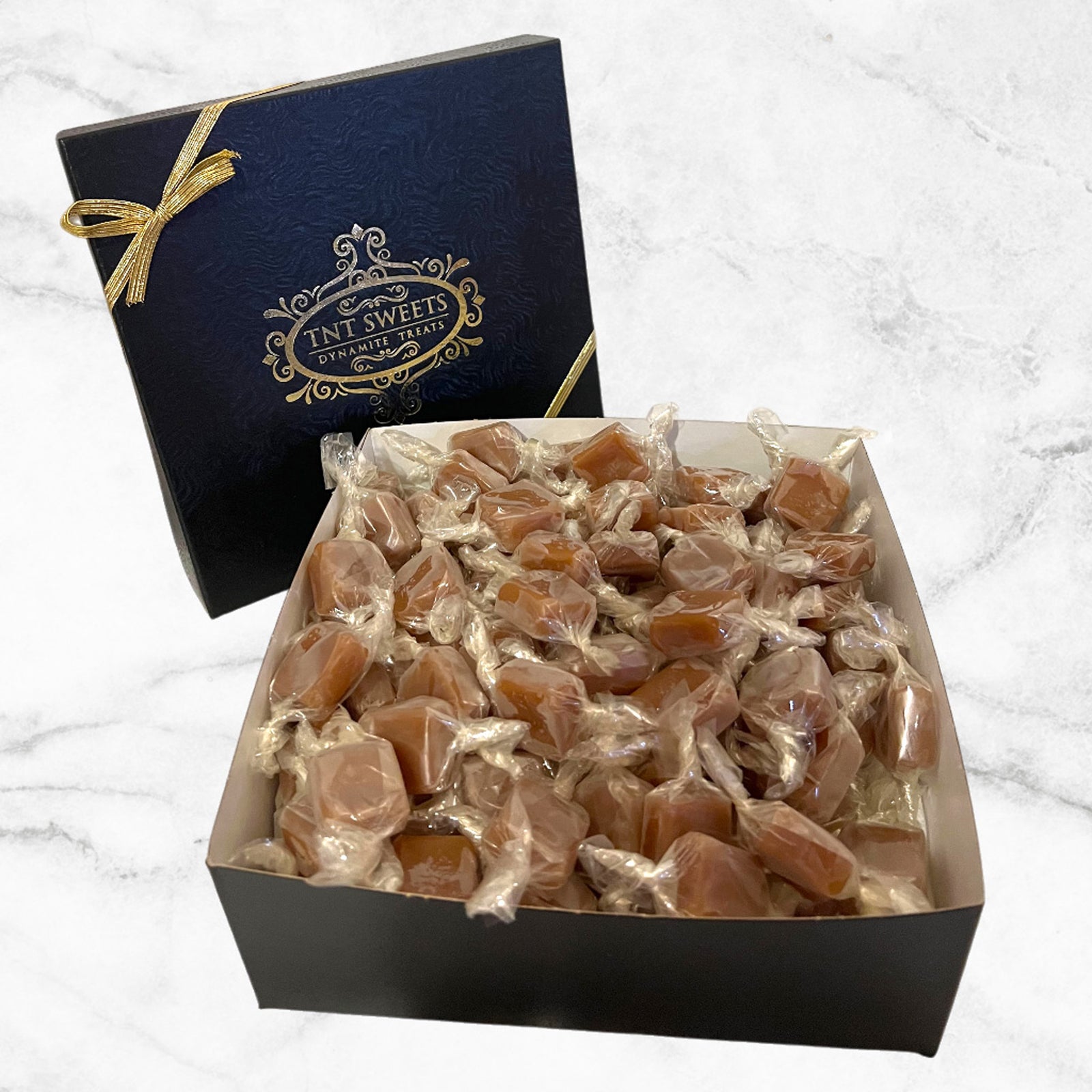 Box of caramels in a a glossy black gift box complete with gold metallic logo.