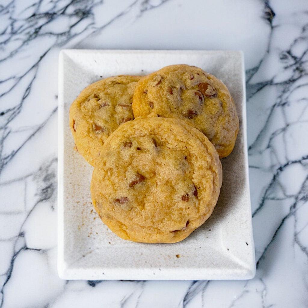 Chocolate Chip cookies on a white tray sitting on a marble countertop.