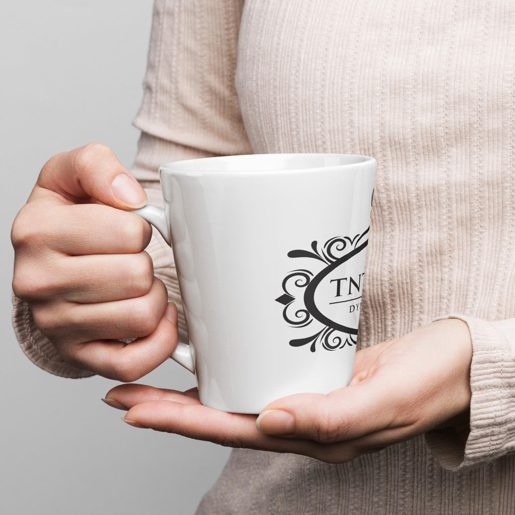 Person holding 12oz white latte mug.