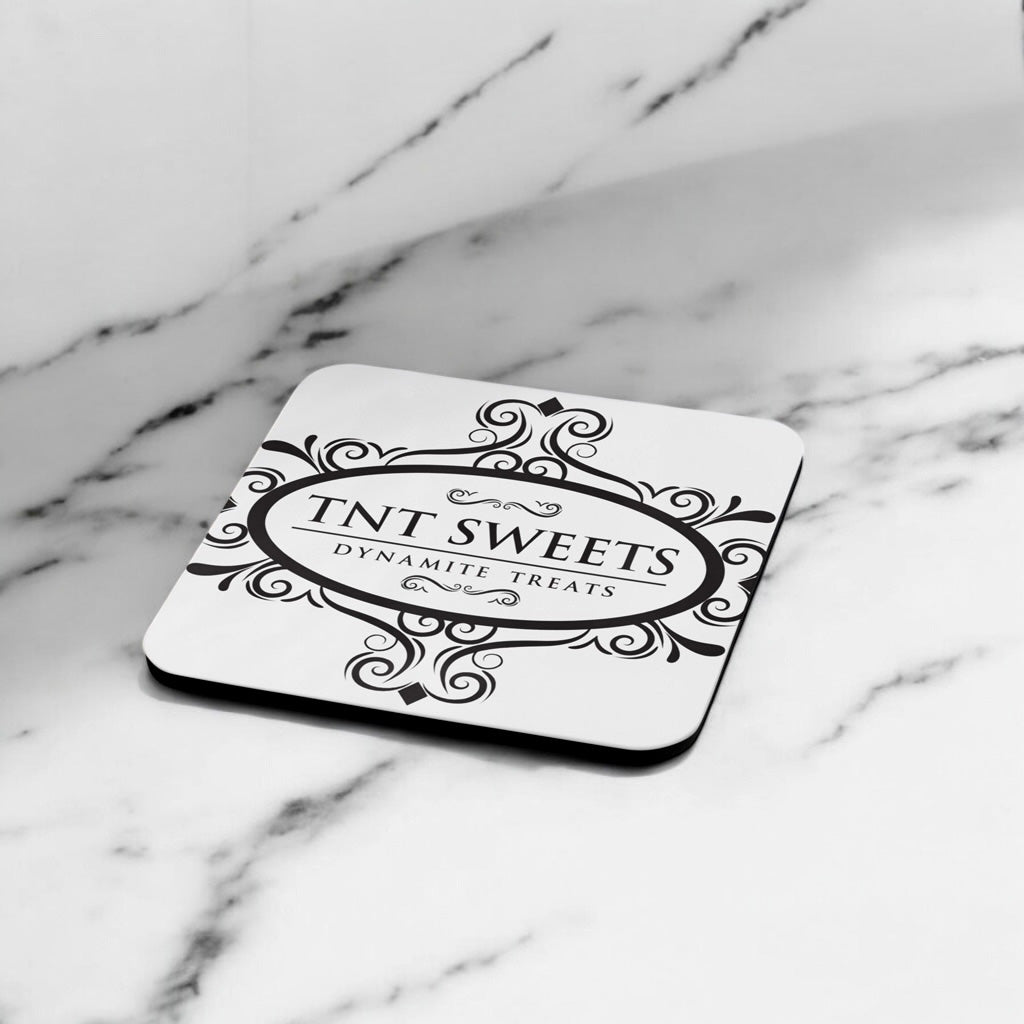 White Ccoaster with TNT Sweets black logo on a marble countertop.