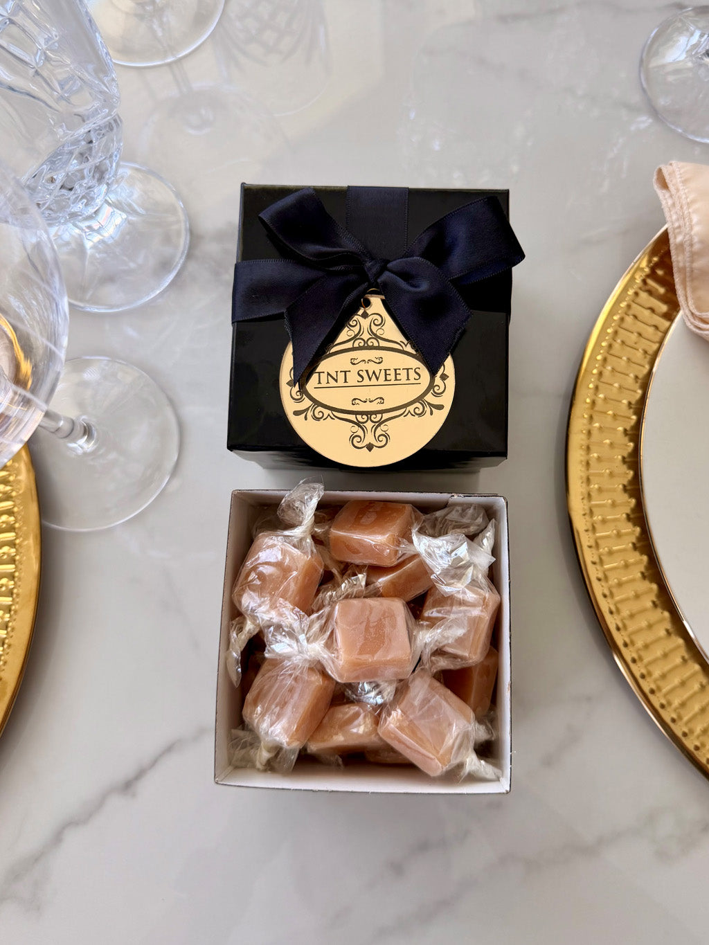Half-pound of Amber Velvet caramels in a black Keepsake Box tied with a black satin ribbon finished with a gold acrylic medallion.