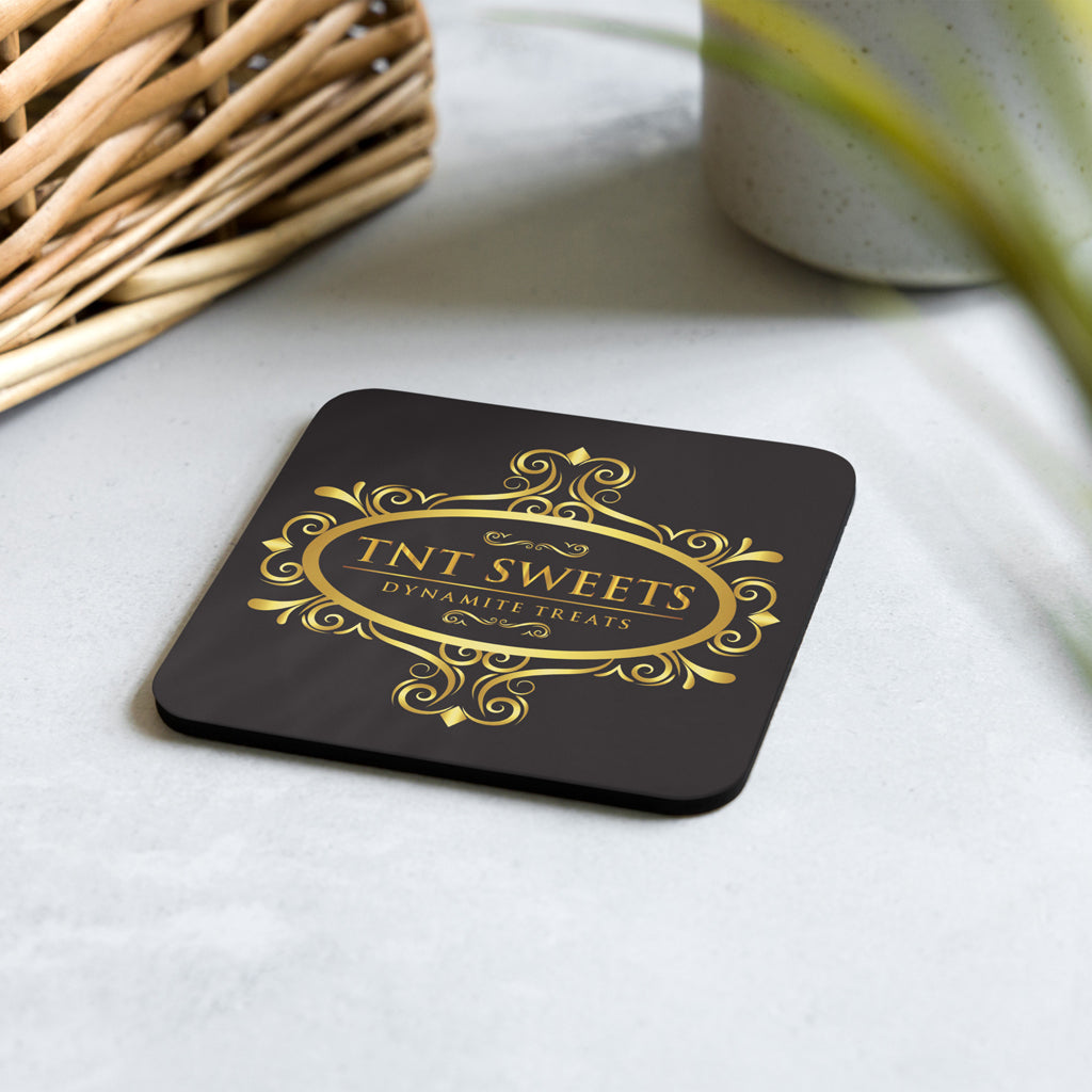 Black coasters with logo on a concrete table with subtle spring decor.