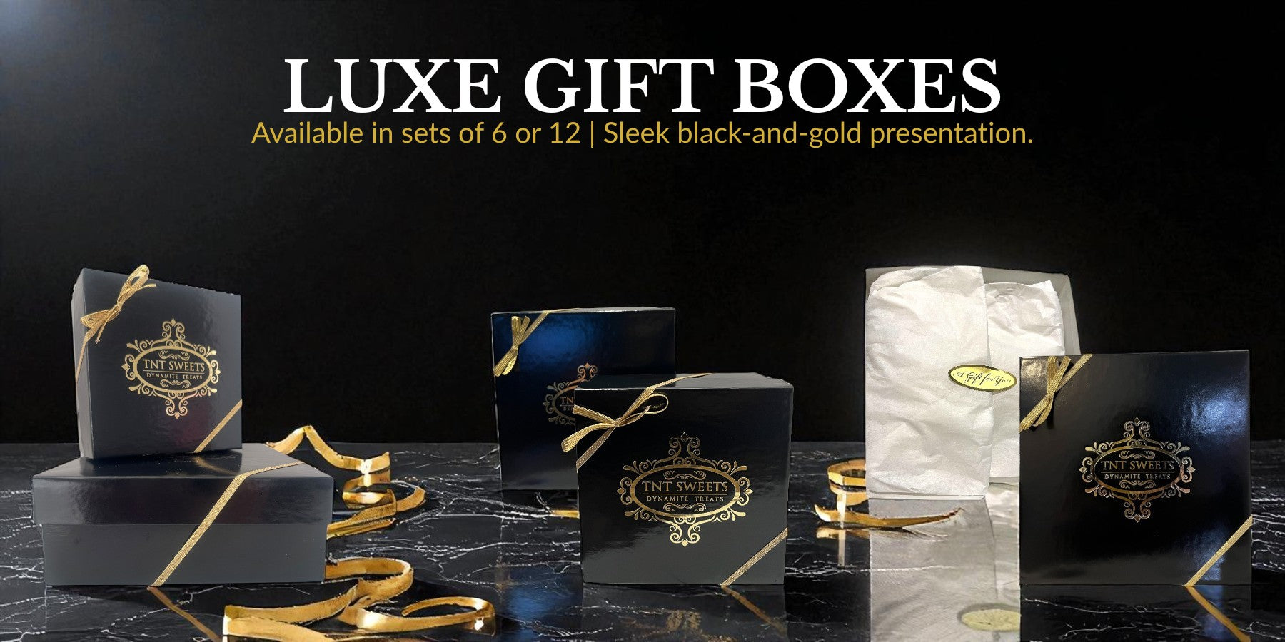 Luxe gift boxes with black and gold design on a dark surface