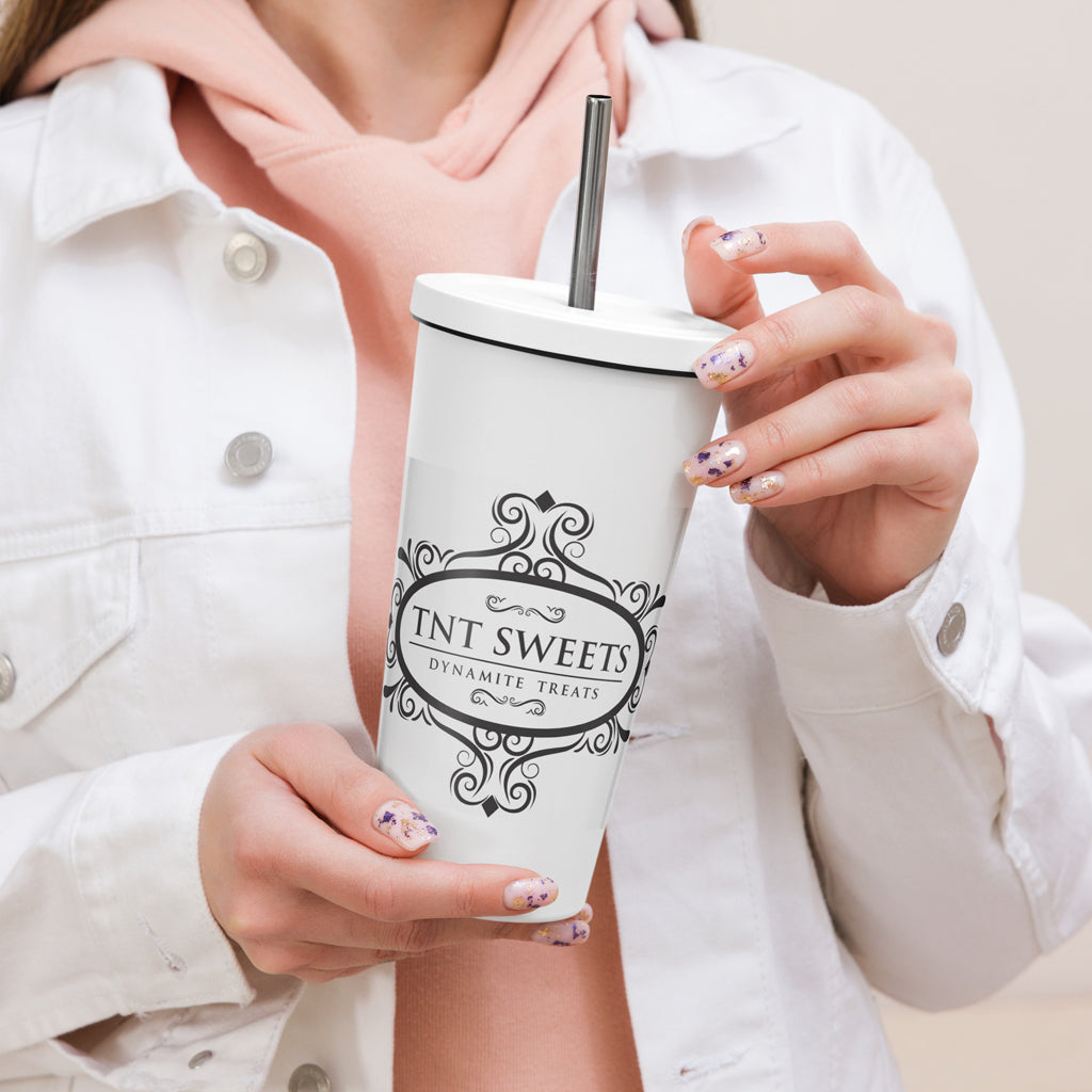 Person holding classic white  tumbler with a black logo with a beige background.