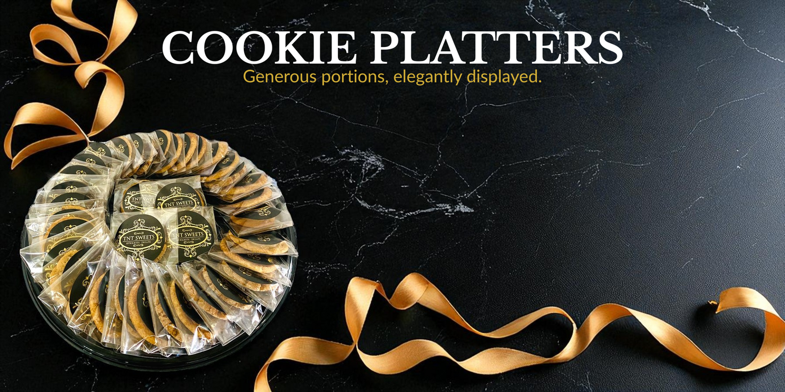 Cookie platter with gold ribbon on a dark marble surface