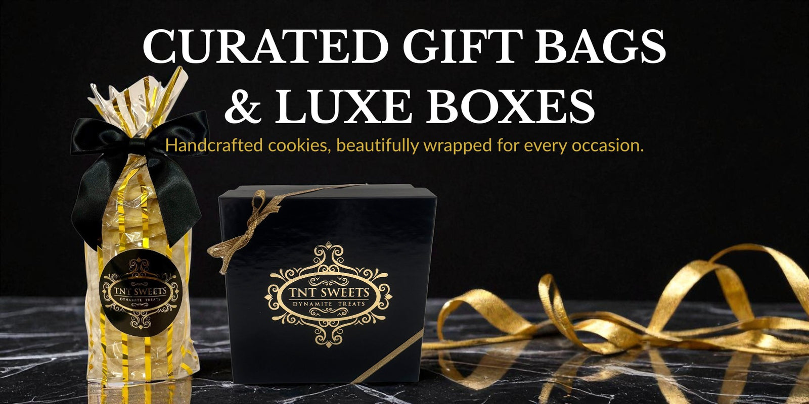 Gift bags and luxe boxes with gold ribbons on a black background
