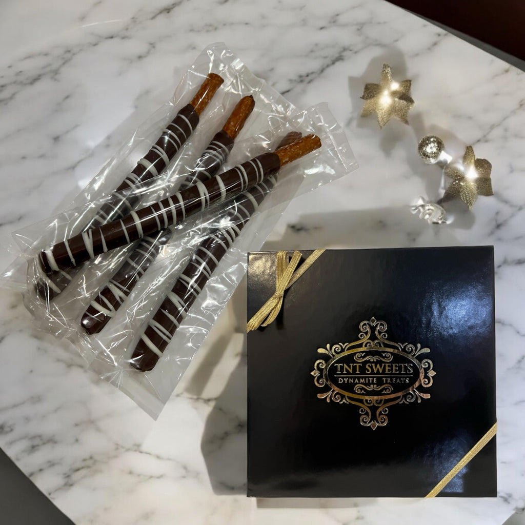 Stacked decor of Dark Chocolate Pretzels in a black gift box on a marble countertop with white and gold decor.