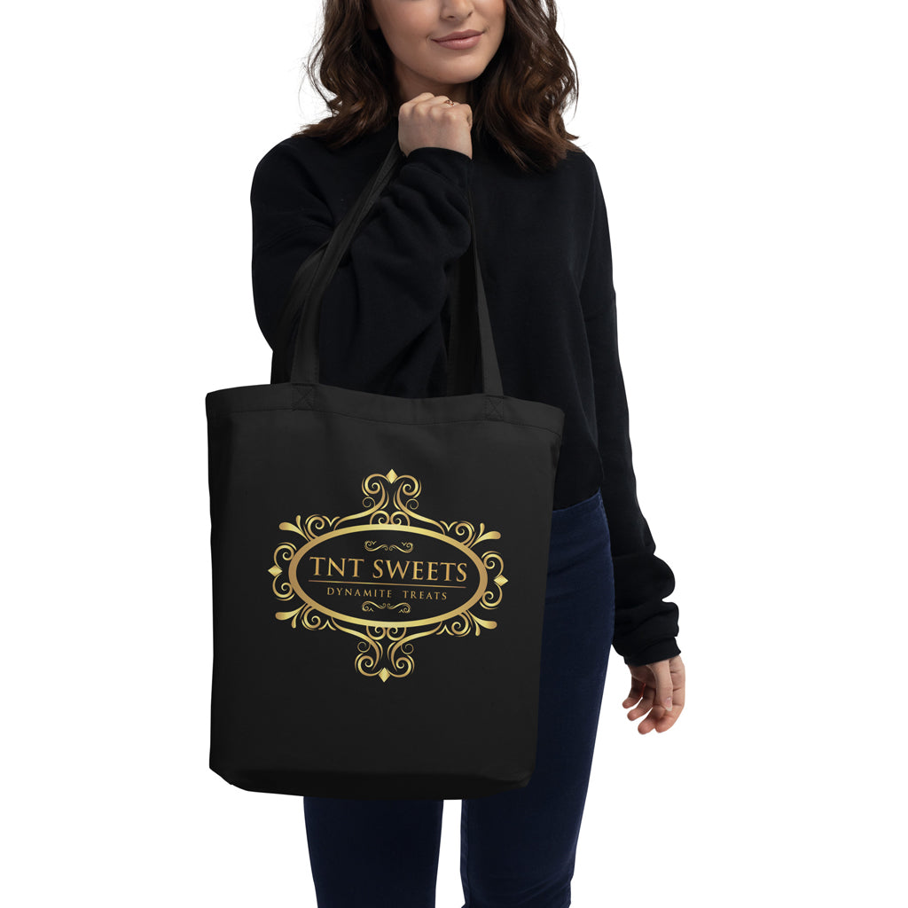 Model holding eco friendly back tote with gold logo with a white background.