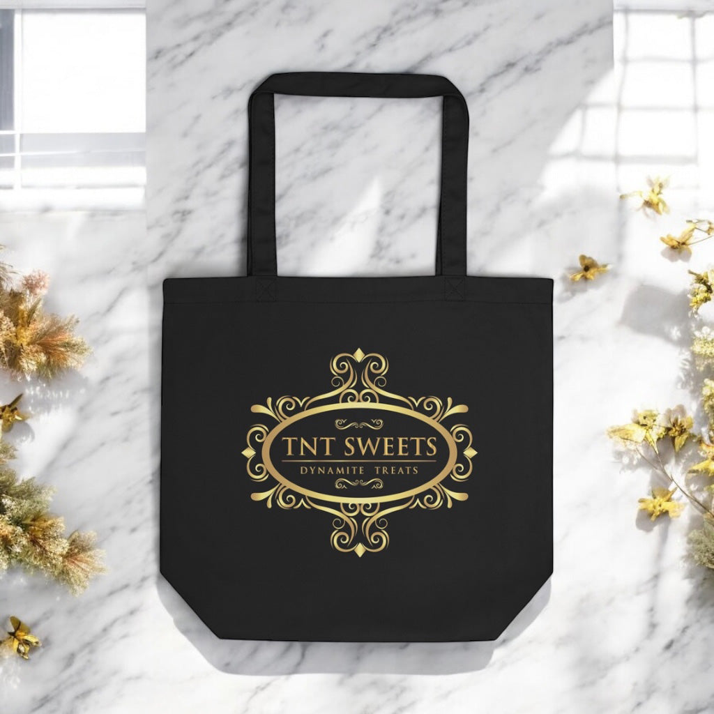 Eco friendly black tote with gold logo on a marble countertop with spring decor in the background.