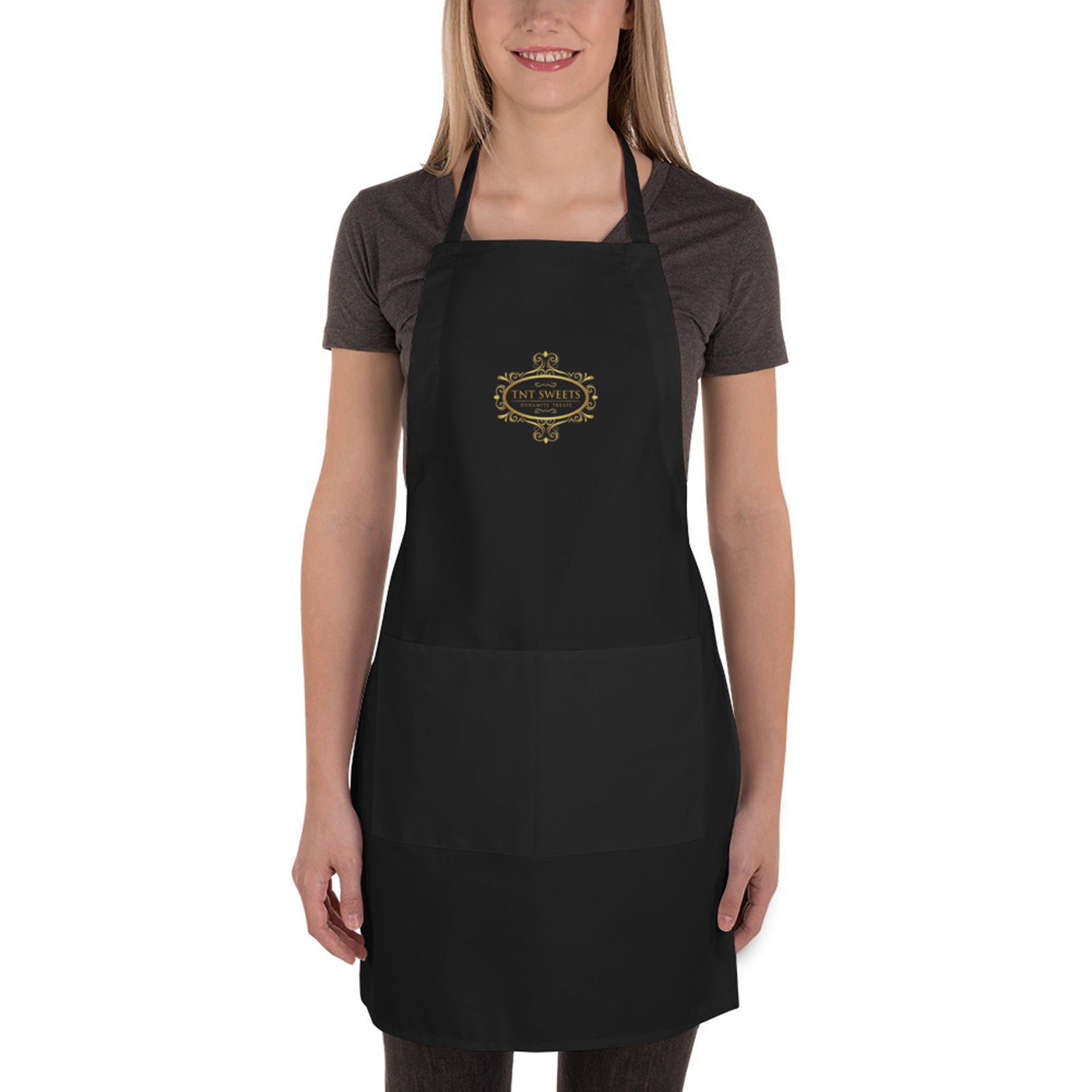 Person wearing a black apron with a gold logo on a white background