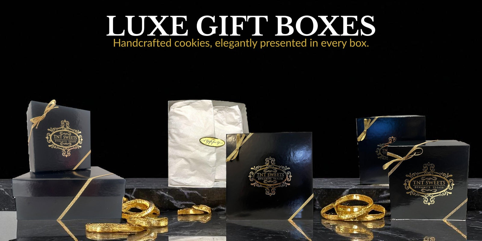 Luxe gift boxes with handcrafted cookies on a black background
