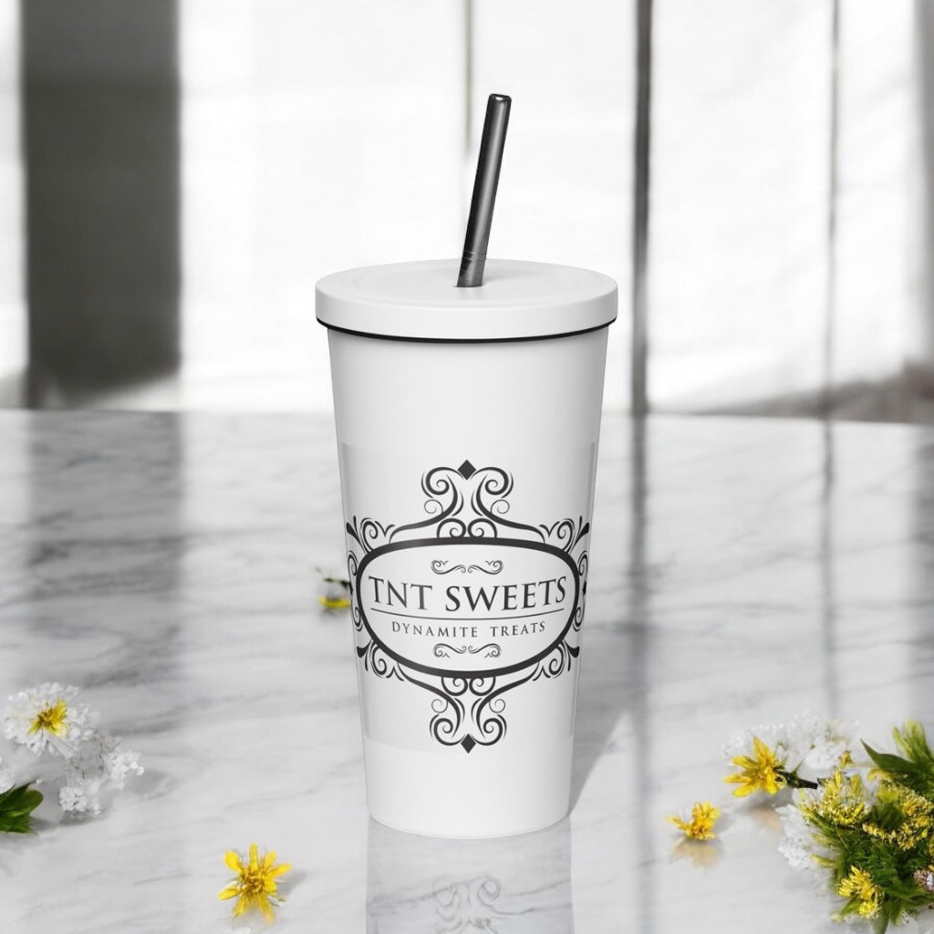 White stainless steel tumbler with a black logo on a marble countertop with spring decor.