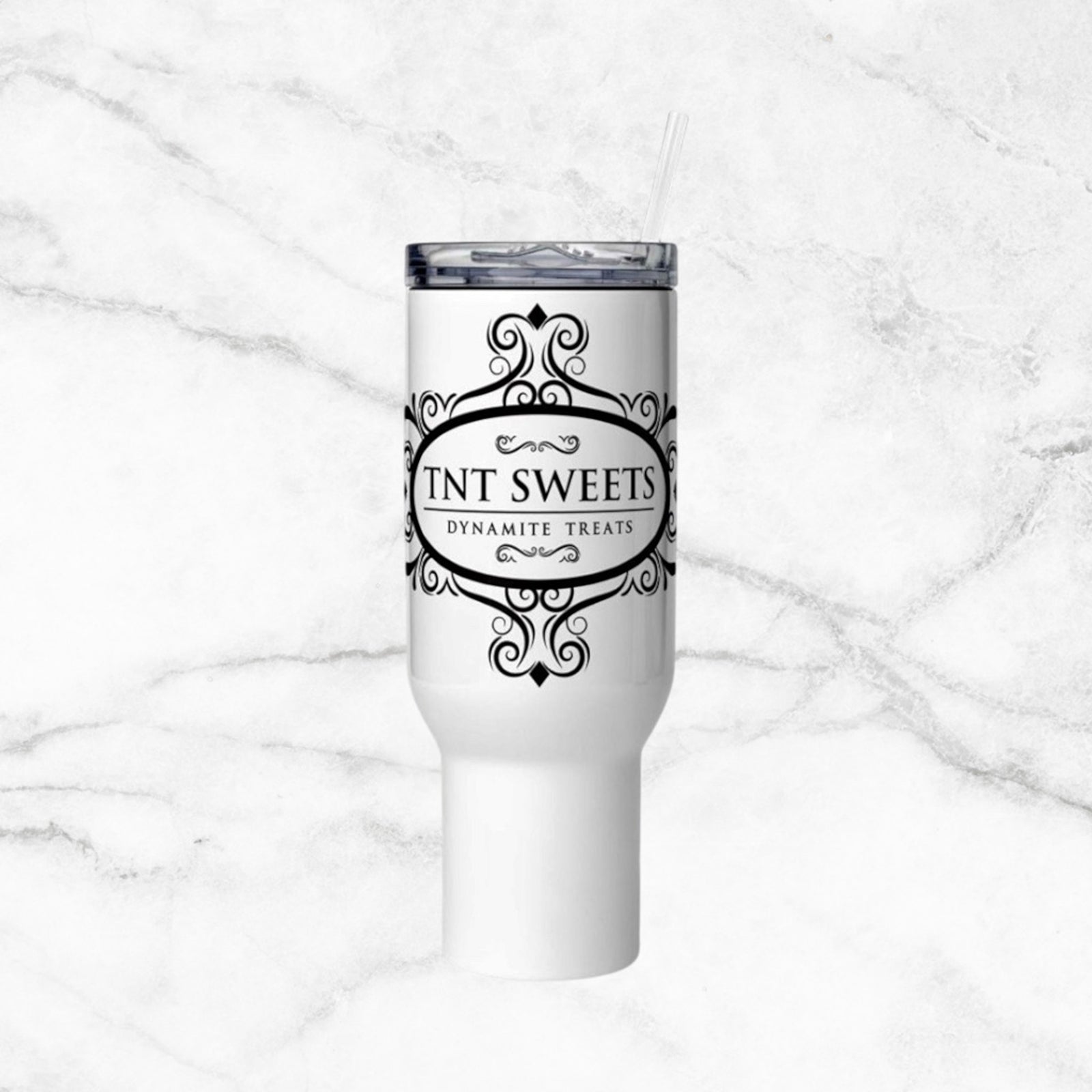 White tumbler with TNT Sweets Dynamite Treats logo on a white marble background.