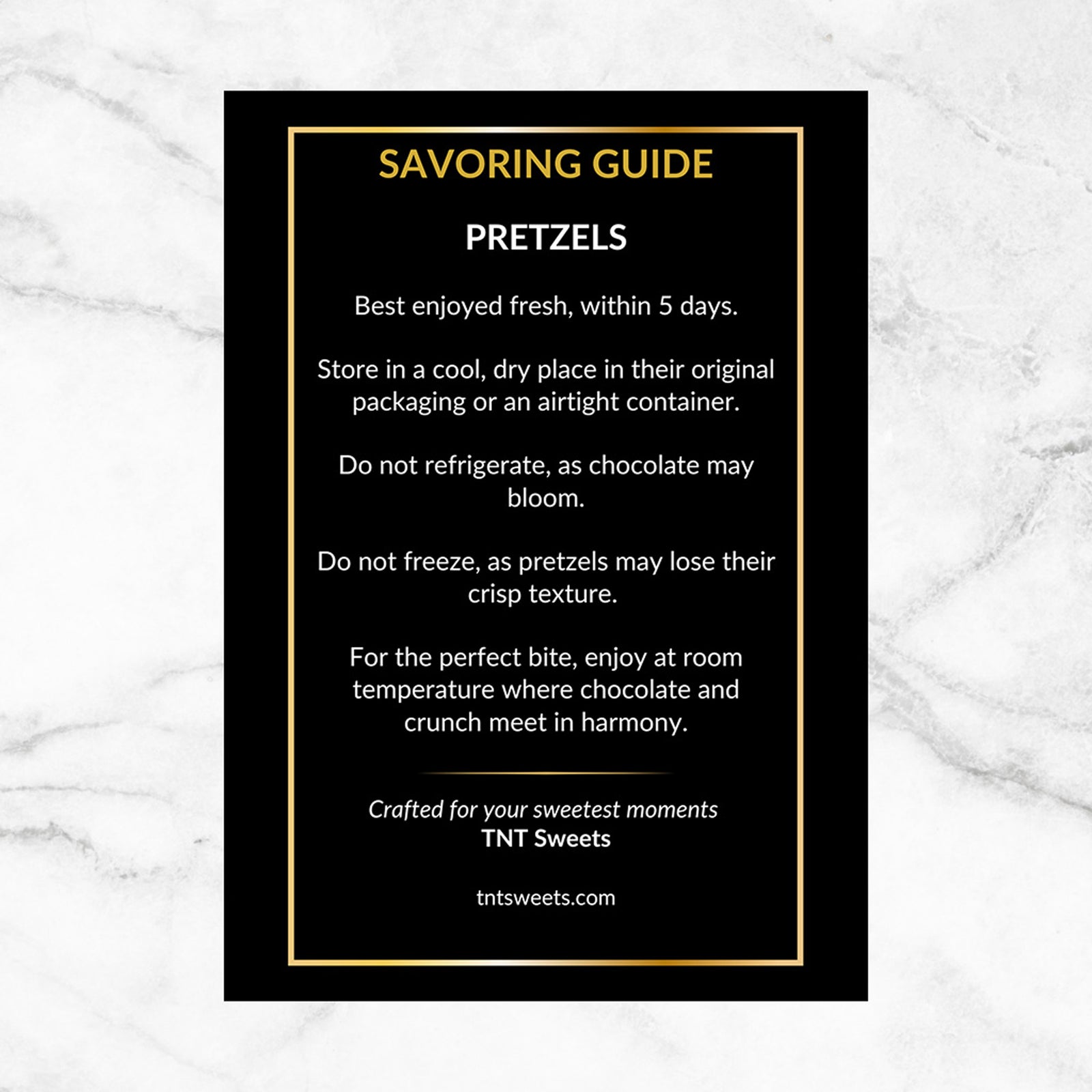 Care instructions for pretzels on a black and gold card on a white marble background. 