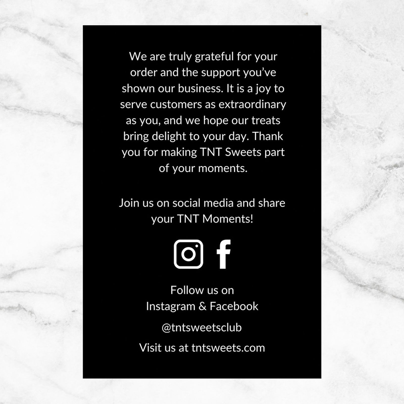 Backside of black thank you card on a marble background.