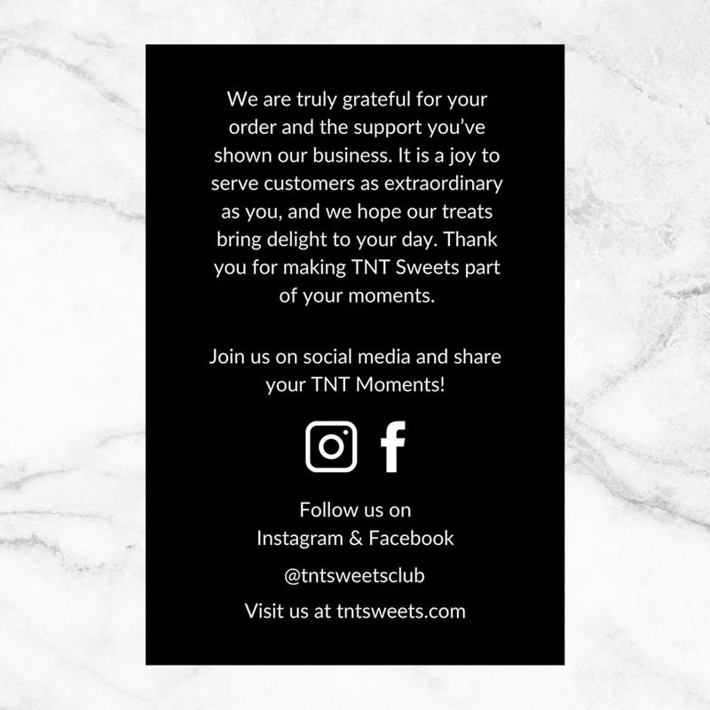 Reverse side of the TNT Sweets thank you card featuring a personalized thank-you message, contact information, and official Facebook and Instagram social media accounts, displayed on a white marble surface.