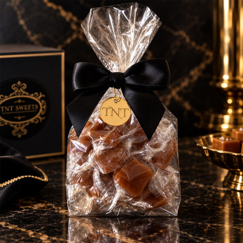 TNT Sweets half pound of Amber Velvet sea salt caramels made with premium European butter. Package finished in our Signature Wrap, TNT Monogram gold medallion and satin black bow.