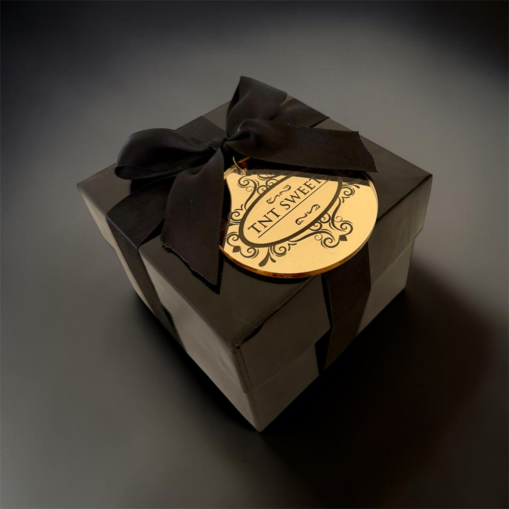 Gift box with a black ribbon and decorative label on a dark background