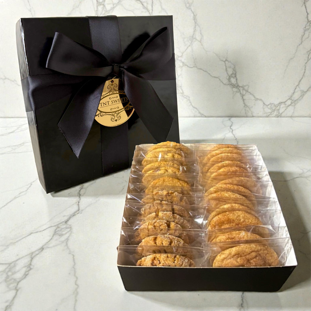 Box of cookies with a black bow on a marble surface