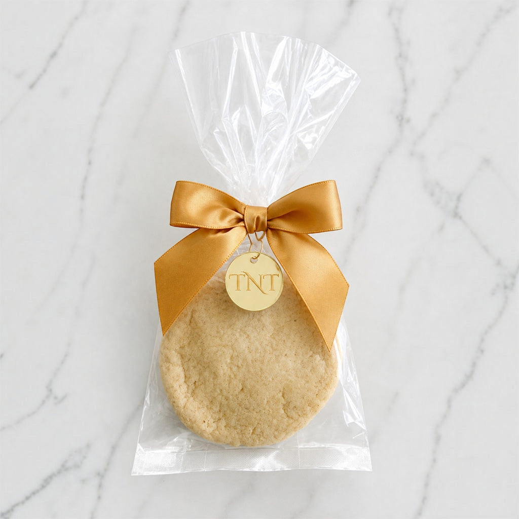 The Première vanilla bean shortbread cookie favor with gold satin ribbon.