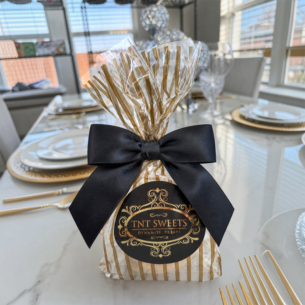 The Première vanilla bean shortbread cookies in TNT Sweets Gold Stripe Wrap with black satin bow.