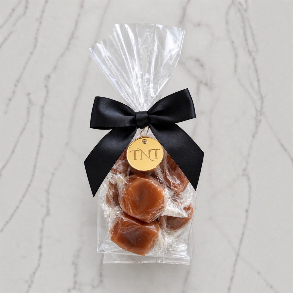 The Accent caramel favor by TNT Sweets with individually wrapped Velvet Heat cayenne caramels, black satin ribbon, and gold TNT medallion.