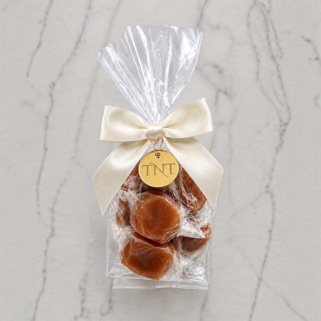 The Accent caramel favor by TNT Sweets with individually wrapped Velvet Heat cayenne caramels, ivory satin ribbon, and gold TNT medallion.