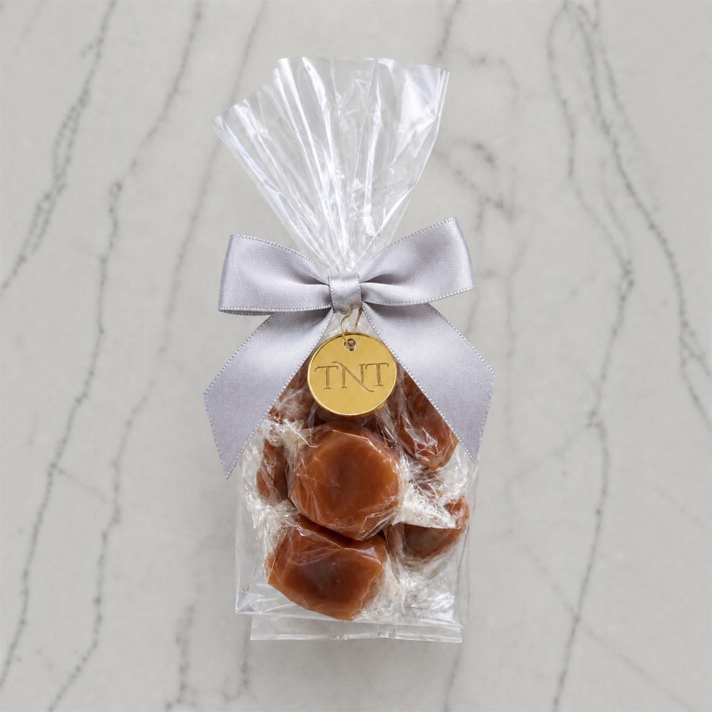 The Accent caramel favor by TNT Sweets with individually wrapped Velvet Heat cayenne caramels, silver satin ribbon, and gold TNT medallion.