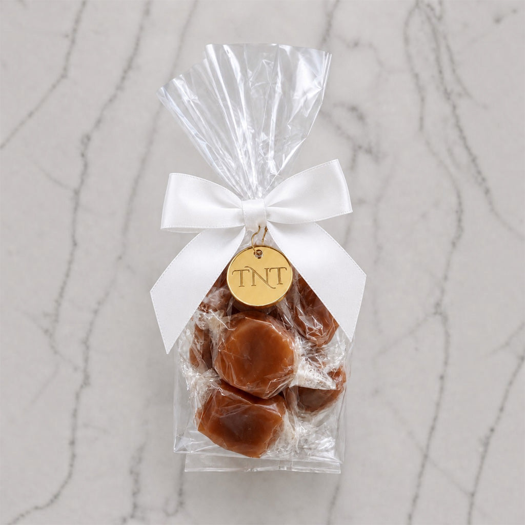 The Accent caramel favor by TNT Sweets with individually wrapped Velvet Heat cayenne caramels, white satin ribbon, and gold TNT medallion.