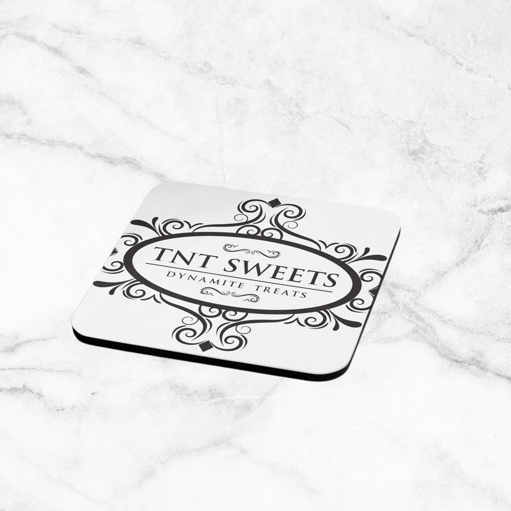 White Ccoaster with TNT Sweets black logo on a marble countertop.